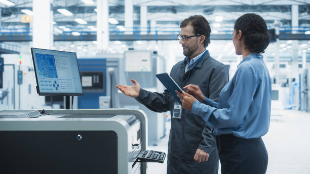 istock Caucasian Industrial Engineer And Hispanic Female Supervisor Using Tablet And Talking At Electronics Factory. Man Using Soldering Jet Printer, Explaining Process Behind Production Of New Microchips. 2189597790