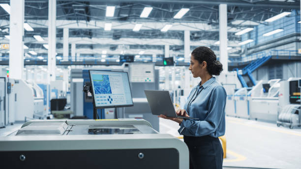 istock Hispanic Female Engineer Using Laptop To Control Soldering Jet Printer On Electronics Factory. Woman Working On Production Of Innovative Circuit Boards For Artificial Intelligence Systems. 2189598379