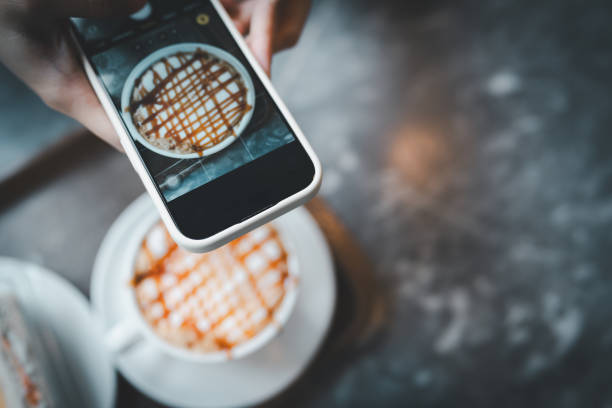 Capturing a Caramel Drizzled Coffee on a Smartphone, Overhead View of a Latte with Artistic Topping, Perfect Blend of Technology and Food Aesthetics in a Cozy Café Setting for Coffee Lovers