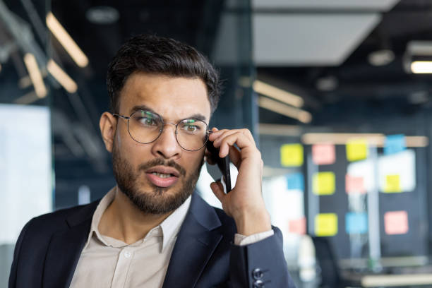 istock Businessman in office talking on phone appearing focused and concerned 2189601892