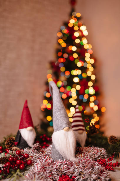 istock Festive Christmas Gnome Decorations with Ornaments and Bokeh Christmas Tree in Background 2189602430
