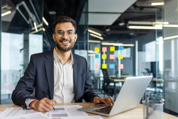 istock Confident businessman working on a laptop in a modern office setting 2189603431