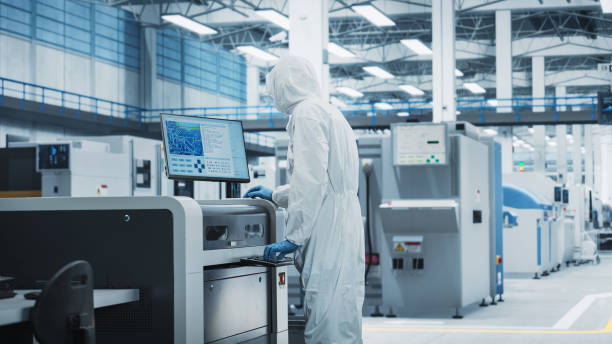 istock Printed Circuit Board Production At Electronics Factory: Scientist In Sterile Suit Using Soldering Jet Printer To Make Motherboards For Powerful Processors. Computer Hardware Manufacturing. 2189603449