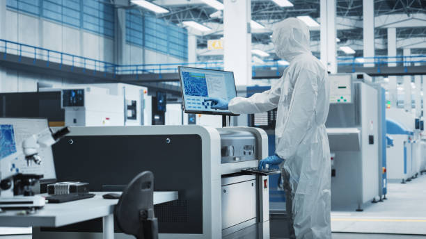 istock Printed Circuit Board Production In Factory Research Center: Scientist In Sterile Suit Using Soldering Jet Printer To Make Motherboards For Computers. Hardware Manufacturing Facility. 2189603531