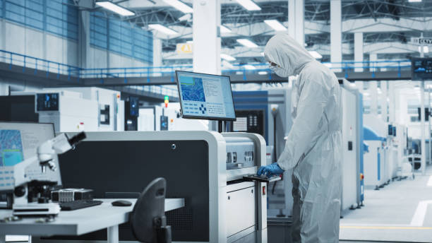 istock Printed Circuit Board Production In Factory Research Center: Scientist In Sterile Suit Using Soldering Jet Printer To Make Motherboards For Powerful Computers. Hardware Manufacturing Facility. 2189603545