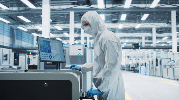 istock Printed Circuit Board Production In a Factory Research Center: Scientist In Sterile Suit Using Soldering Jet Printer To Make Motherboards For Powerful Computer. Hardware Manufacturing Facility. 2189603630