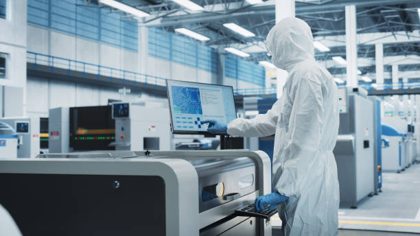 istock Printed Circuit Board Production In Electronics Factory Cleanroom: Scientist In Sterile Suit Using Soldering Jet Printer To Make Motherboards For Powerful CPU. Computer Hardware Manufacturing Facility 2189603720