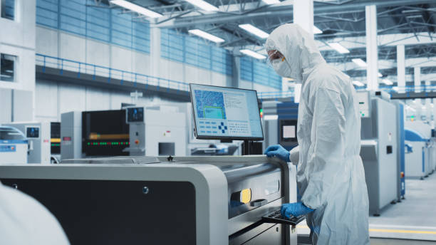 istock Printed Circuit Board Production At Electronics Factory: Scientist In Sterile Suit Using Soldering Jet Printer To Make Motherboard For Powerful CPUs. Powerful Computer Hardware Manufacturing Facility. 2189603735