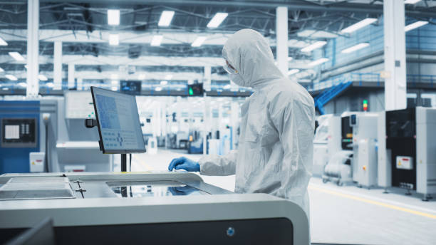 istock Printed Circuit Board Production At Electronics Factory: Scientist In Sterile Suit Using Soldering Jet Printer To Make Motherboards For Powerful CPU. Computer Hardware Manufacturing Facility. 2189603948