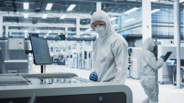 istock Printed Circuit Board Production At Electronics Factory: Scientist In Sterile Suit Using Soldering Jet Printer To Make Motherboards For Powerful CPUs. Computer Hardware Manufacturing Facility. 2189604017