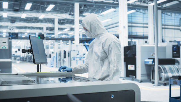 istock Printed Circuit Board Production At Electronics Factory: Scientist In Sterile Suit Using Soldering Jet Printer To Make Modern Motherboards For Powerful CPUs. Computer Hardware Manufacturing Facility. 2189604055