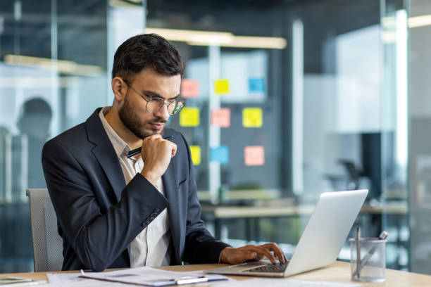 istock Focused businessman working at computer in modern office environment, contemplating important decisions and planning strategies, showcasing a professional setting with digital connectivity 2189604997