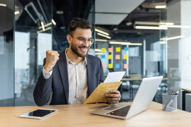 Excited businessman reading a positive letter in modern office setting