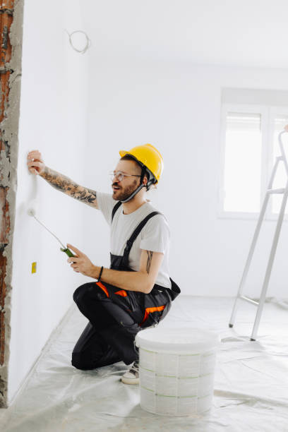 istock Young painter - construction worker painting a wall indoors 2189608425
