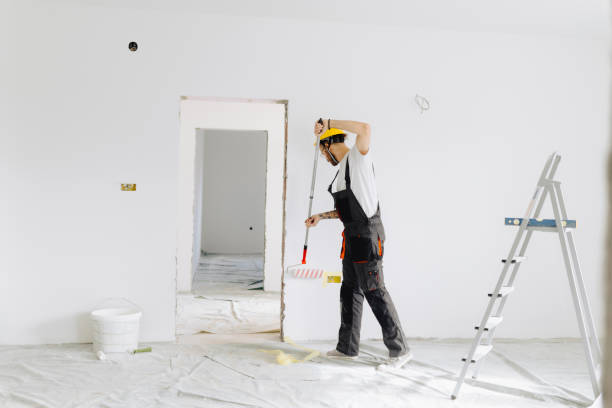 istock Young painter - construction worker painting a wall indoors 2189608591