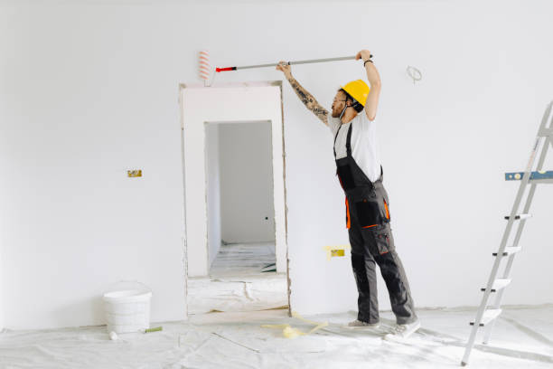 istock Young painter - construction worker painting a wall indoors 2189608666