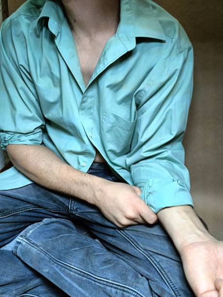 man rolls up shirt sleeves