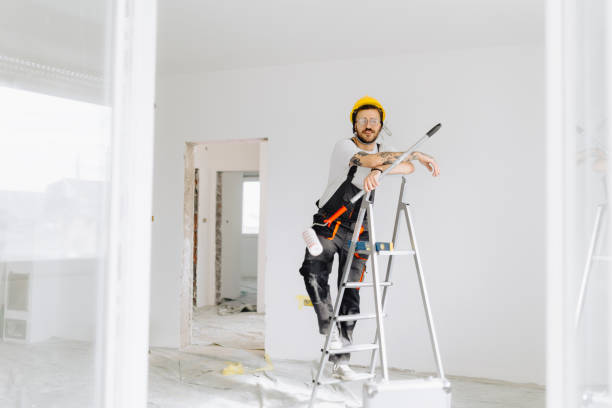 istock Young painter - construction worker painting a wall indoors 2189608740