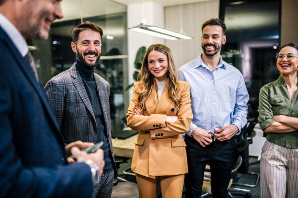 istock Group of business professionals standing in a modern office, engaged in a lively conversation 2189609533