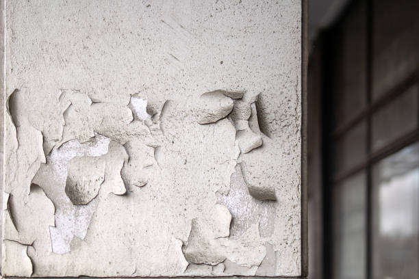 istock square pillar, its paint peeling in chunks, revealing a weathered texture beneath. This juxtaposition of decay and structure evokes themes of time, neglect, and resilience 2189610783