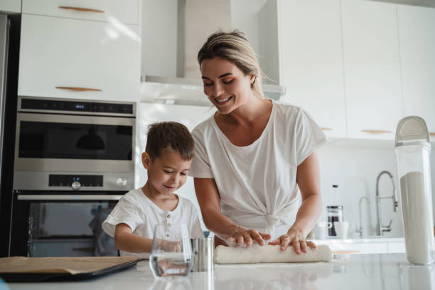 istock Happy mother and her son baking together in a modern kitchen. 2189613392