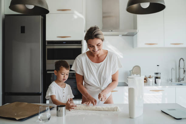 istock Happy mother and her son baking together in a modern kitchen. 2189613425