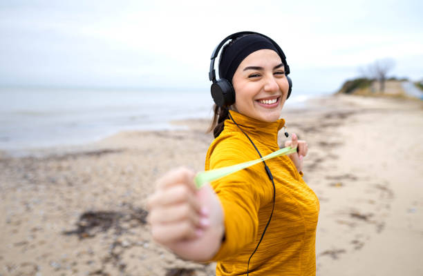Young smiling Woman exercising and jogging during the wintertime at the beach