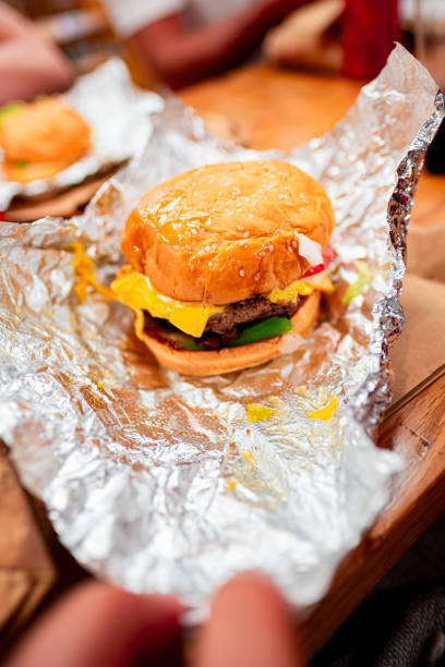 istock Delicious Cheeseburger Unwrapped in Foil with Fresh Toppings 2189618653
