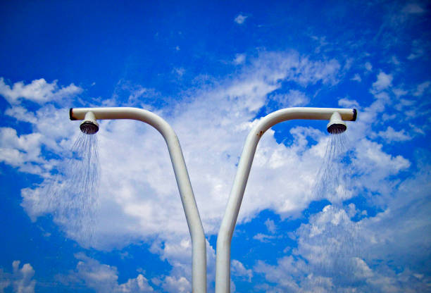 Beach shower with running water against a blue sky with white clouds