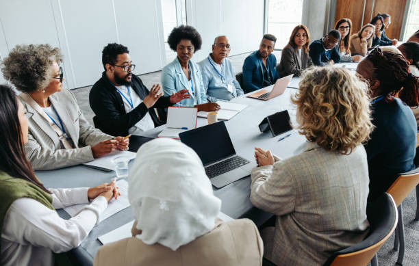 Multiethnic group of businesspeople brainstorming and strategizing in a meeting Multiethnic group of businesspeople engaged in a strategy and brainstorming session around a conference table. Collaborative and focused on teamwork and planning. organization stock pictures, royalty-free photos & images