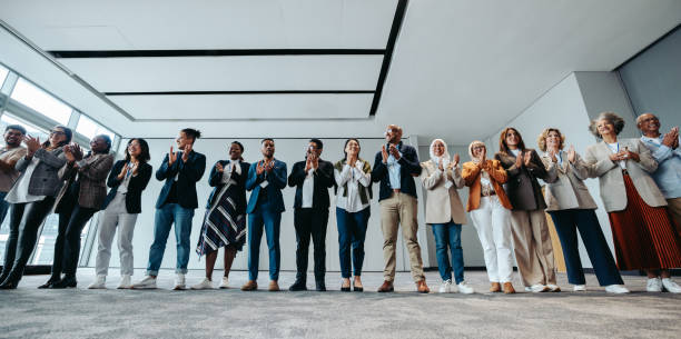 istock Diverse group of business people clapping at a seminar in a modern workshop 2189621788