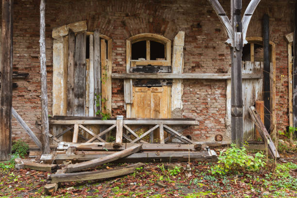 Old wooden closed door in a concrete block wall. Entrance to the premises. Old door on the farm.