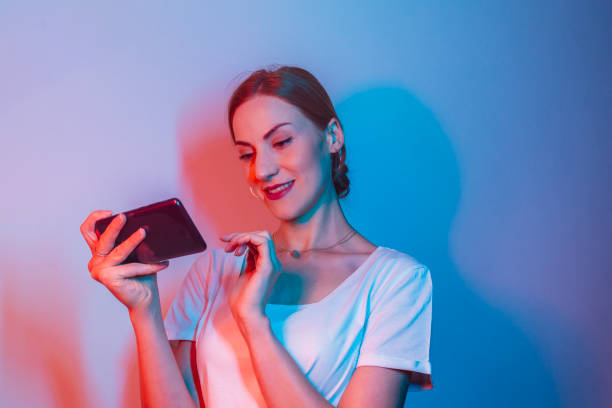 istock A woman is holding a cell phone and smiling. 2189628755