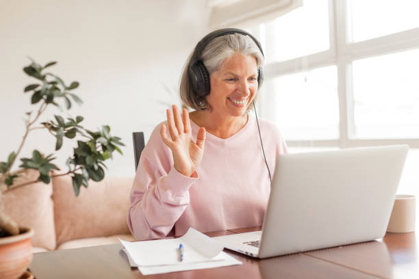 istock Middle aged businesswoman using earphone while sitting behind her laptop 2189628956