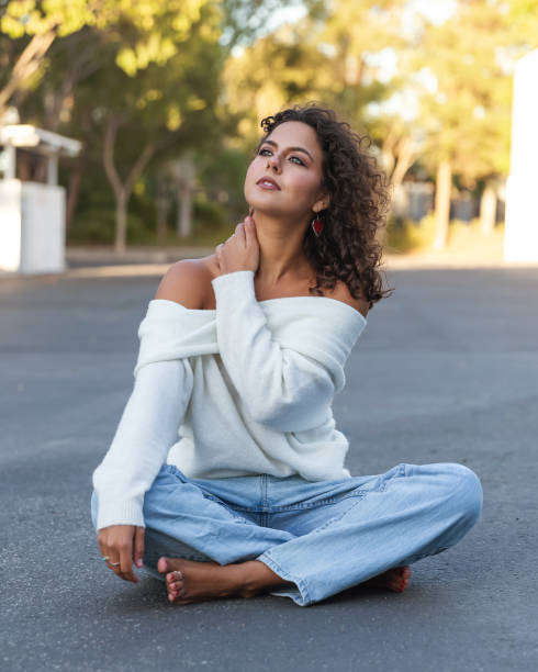 istock Young woman in cozy off shoulder white sweater 2189629695