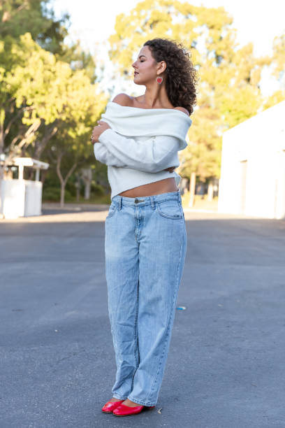 istock Young woman in cozy off shoulder white sweater 2189629793
