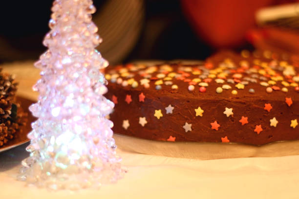 Christmas tree decoration and colorful cake on the holiday table. Selective focus.