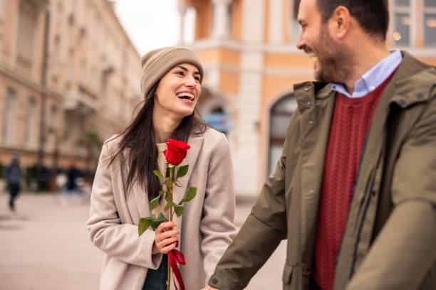 istock Caucasian Male Joyfully Surprises Partner with Rose 2189634081