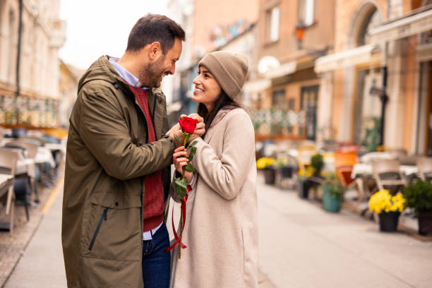istock Caucasian Male Joyfully Surprises Partner with a Rose 2189634093
