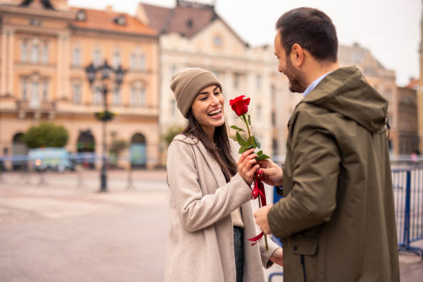 istock Caucasian Male Joyfully Surprises Partner with Rose 2189634243