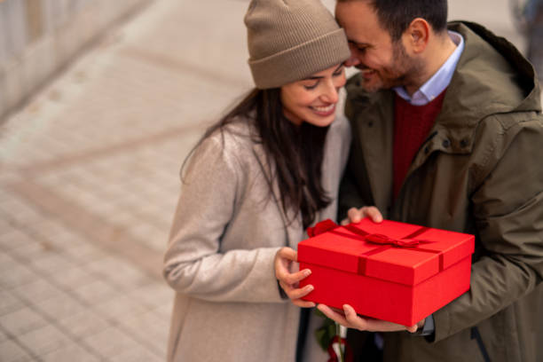 istock Caucasian Man Joyfully Surprises Wife with Gift 2189634354
