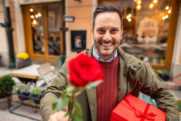 istock Charming Caucasian Man Smiling Holding Gift and Rose 2189634558