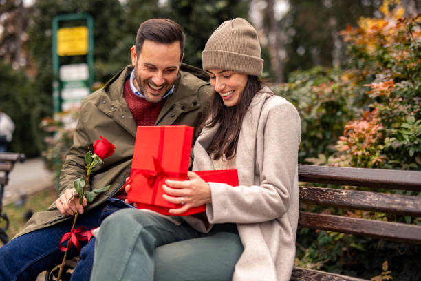 istock Joyful Caucasian Man Surprises Partner with Gift in Park 2189634751