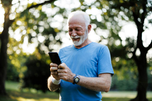 istock Senior sporty man using smart phone while exercising in nature 2189636568