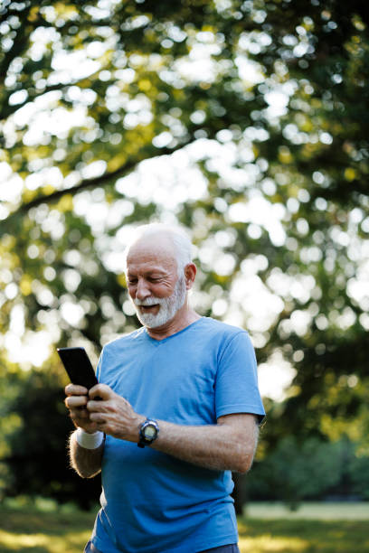istock Senior sporty man using smart phone while exercising in nature 2189636743