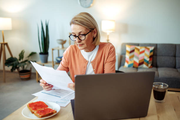 istock Mature woman working at home while having breakfast 2189640199