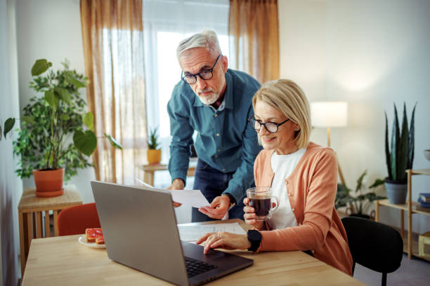 istock Mature couple going over bills and documents at home together 2189640212