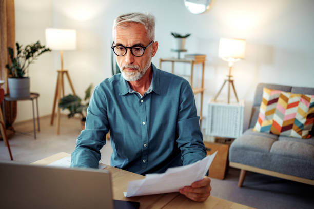 istock Mature man going over bills at home 2189640228