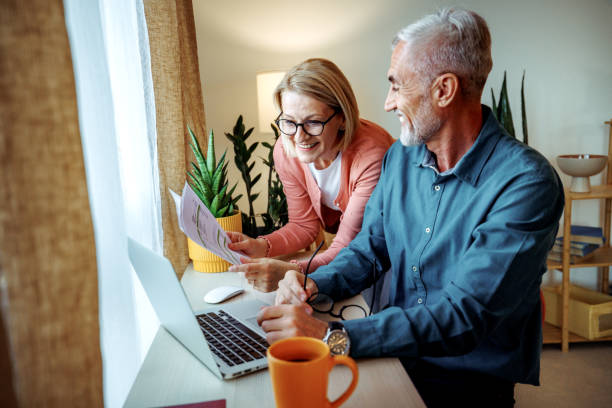 istock Smiling mature couple using laptop at home together 2189640884