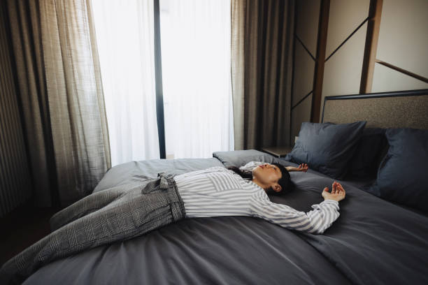 istock Tired woman lying on bed in hotel 2189646731